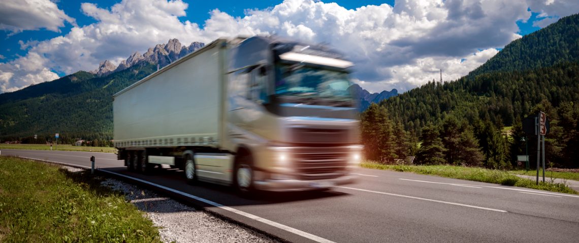 Fuel truck rushes down the highway in the background the Alps. Truck Car in motion blur.